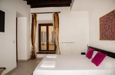 a bedroom with a large white bed with pink pillows at Boschetto49 in Rome
