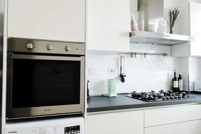 a white kitchen with a stove and a microwave at ophelia apartment in Rome