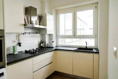 a kitchen with white cabinets and a sink and a window at ophelia apartment in Rome