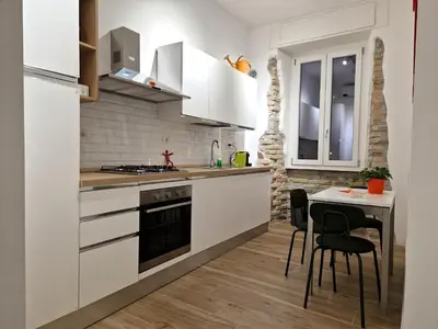 a kitchen with white cabinets and a small table at Varia Domus in Rome