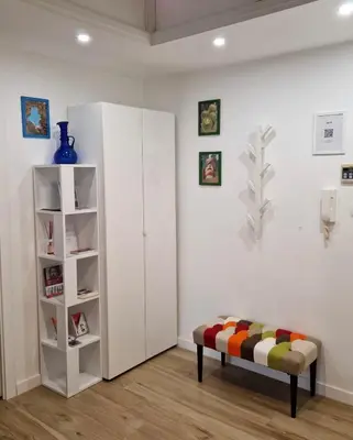 a white room with a bench and a book shelf at Varia Domus in Rome