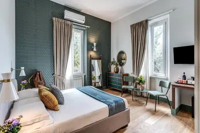 a hotel room with a bed and a desk and chairs at Tree Charme Trilussa in Rome