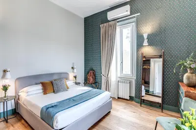 a bedroom with a bed in a room with green wallpaper at Tree Charme Trilussa in Rome
