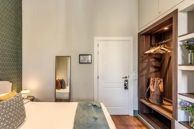 a bedroom with a white bed and a door at Tree Charme Trilussa in Rome