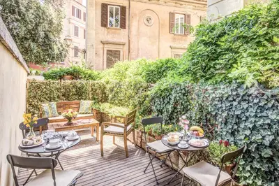 a patio with a table and chairs and a fence at Tree Charme Trilussa in Rome