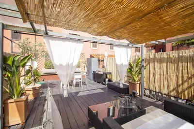 an outdoor patio with a wooden deck with white curtains at Scuderie San Lorenzo in Rome