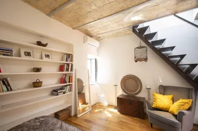 a living room with a staircase and a chair at Scuderie San Lorenzo in Rome