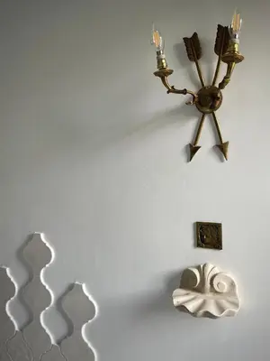 a wall with a chandelier and a mask on a wall at Casetta Roma San Giovanni in Rome