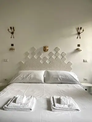 a bedroom with a white bed with two towels on it at Casetta Roma San Giovanni in Rome