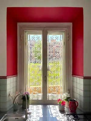 a kitchen with a sink and a window with red walls at Casetta Roma San Giovanni in Rome