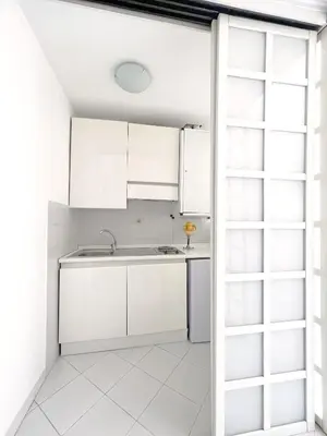 a kitchen with white cabinets and a window at Trevi over the top apartment in Rome