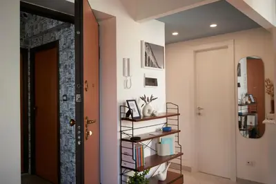 a hallway with a door and a shelf with books at Bivio - Casa Azzurra in Rome