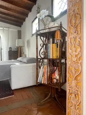 a book shelf next to a bed with books at Attico Le Castelline in Rome