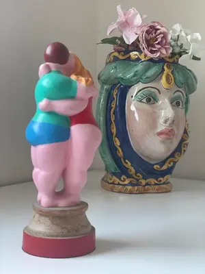 a statue of a woman standing next to a vase at Attico Le Castelline in Rome