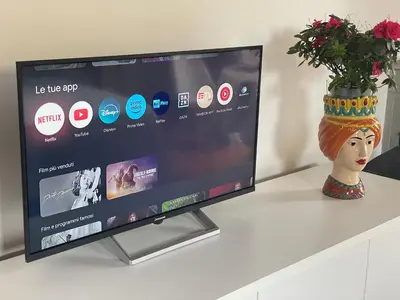 a flat screen tv sitting on a table with a vase at Attico Le Castelline in Rome