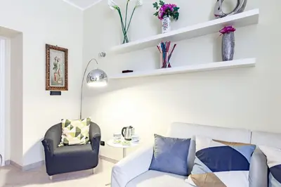 a living room with a couch and a chair at Hostly-Volturno Suite Apartment-Center of Rome in Rome