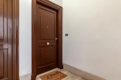 a door with a welcome mat in front of a room at Hostly-Volturno Suite Apartment-Center of Rome in Rome