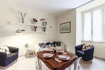 a living room with a dining room table and chairs at Hostly-Volturno Suite Apartment-Center of Rome in Rome