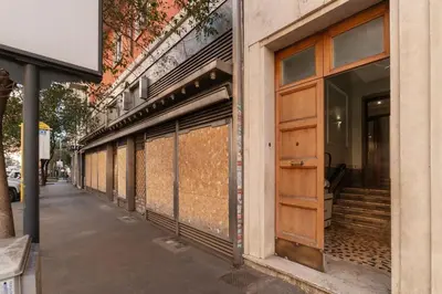 a row of windows on a building with a wooden door at GuestHost - Chic Stay at Magnagrecia Rome Apartment in Rome