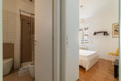 a bedroom with a bed and a bathroom at GuestHost - Chic Stay at Magnagrecia Rome Apartment in Rome