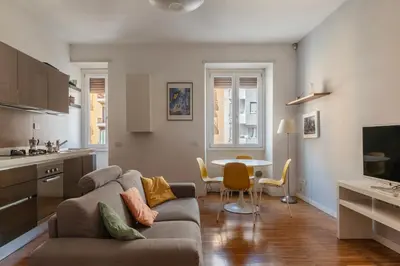 a living room with a couch and a table at GuestHost - Chic Stay at Magnagrecia Rome Apartment in Rome
