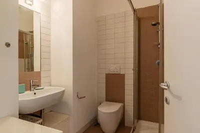 a bathroom with a sink and a toilet and a shower at GuestHost - Chic Stay at Magnagrecia Rome Apartment in Rome