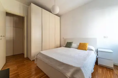 a bedroom with a large white bed with yellow pillows at GuestHost - Chic Stay at Magnagrecia Rome Apartment in Rome