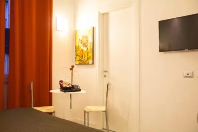 a hotel room with a bed and a television on a wall at La Torre Guest House in Rome