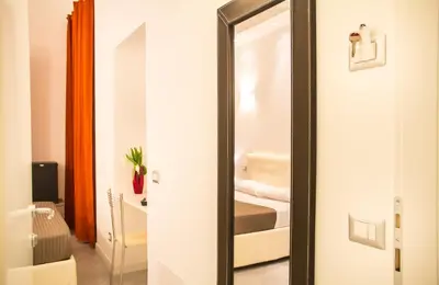 a mirror in a room with a bed at La Torre Guest House in Rome