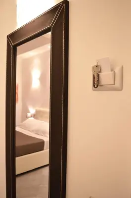 a mirror hanging on a wall next to a bed at La Torre Guest House in Rome