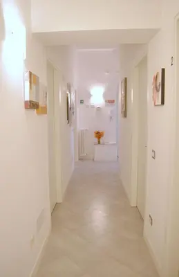 a hallway with white walls and a tile floor at La Torre Guest House in Rome