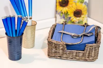 a basket with pens and a vase with a sunflower at La Torre Guest House in Rome