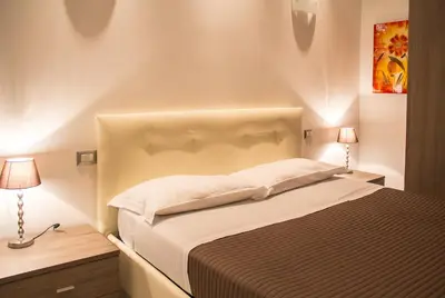 a bedroom with a large bed with two lamps at La Torre Guest House in Rome