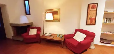 a living room with two red chairs and a table at La Torre del Moro - RH Collection in Rome