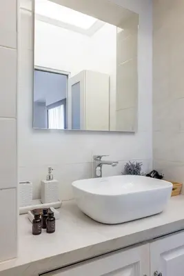 a white bathroom with a sink and a mirror at DOMUS GIULIA in Rome