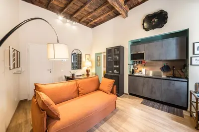 a living room with an orange couch and a kitchen at Sciampagne in Rome