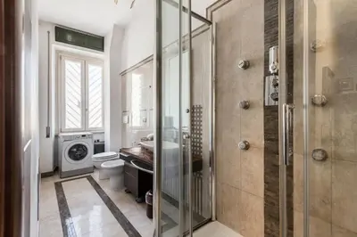 a bathroom with a shower and a washing machine at HOME Suitte in San Giovanni near Basilica - Roma - in Rome