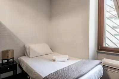 a small bedroom with a bed and a window at HOME Suitte in San Giovanni near Basilica - Roma - in Rome