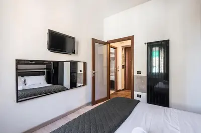 a bedroom with a bed and a television on a wall at HOME Suitte in San Giovanni near Basilica - Roma - in Rome