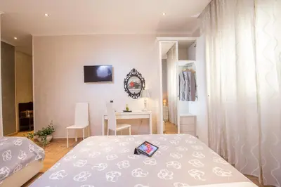 a hotel room with two beds and a table at Starry Rome Guest House in Rome