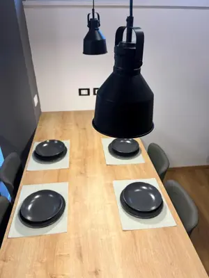 a table with four black plates and lights on it at AThome104 in Rome