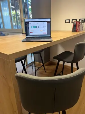 a laptop computer sitting on a wooden desk with a chair at AThome104 in Rome