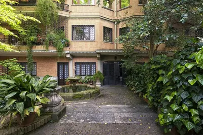 a building with a courtyard with plants and a fountain at Vatican House Apartment in Rome