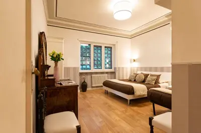 a table and chairs on a patio with trees at Vatican House Apartment in Rome
