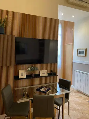 a dining room with a table and a television on a wall at Elian Apartament in The Center of Rome #3 Colosseo in Rome
