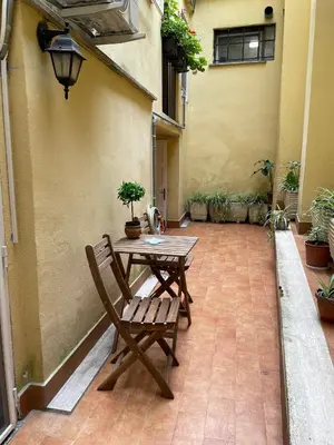 a patio with a wooden table and a chair at Elian Apartament in The Center of Rome #3 Colosseo in Rome