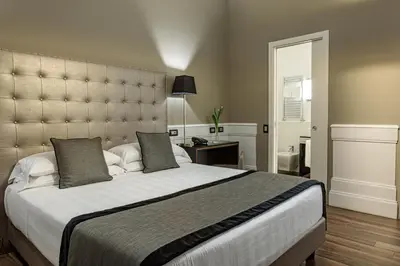 a bedroom with a large bed with a large headboard at The Independent Suites in Rome