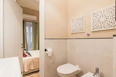a bedroom with a bed and a desk with a red chair at NEW! Monti 63 in Rome