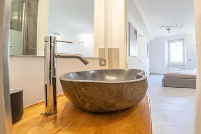 a bathroom with a large metal sink on a wooden floor at Vivi la Magia di Looney Tunes, piazza navona in Rome