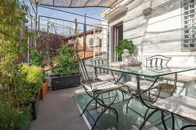 a patio with a glass table and chairs on a balcony at Vivi la Magia di Looney Tunes, piazza navona in Rome